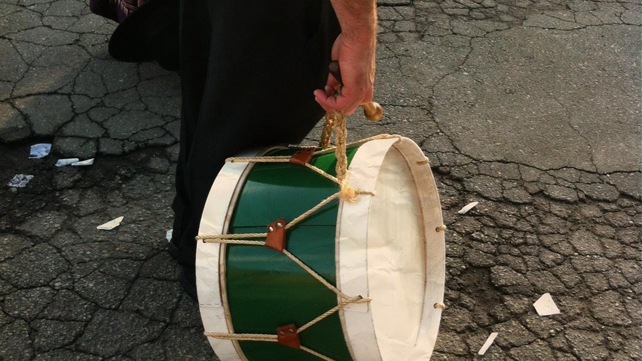 Persona lleva un tambor de la mano 