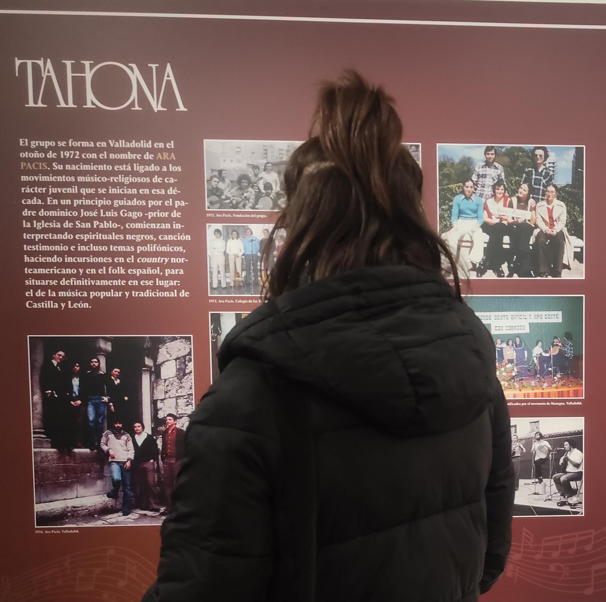 Mujer viendo tríptico de la exposición Tahona